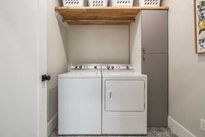 Laundry area with washer and dryer and baseboards