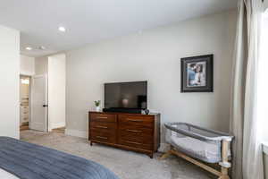 Bedroom with light carpet and recessed lighting