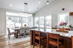 Dining room featuring light wood-style flooring, lofted ceiling, recessed lighting, and plenty of natural light