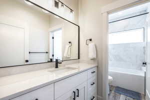 Bathroom featuring vanity, light wood-type flooring, and shower / bath combination
