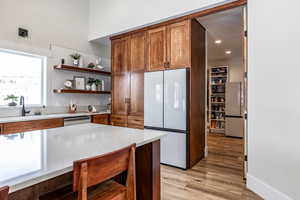 Kitchen with freestanding refrigerator, open shelves, light wood-type flooring, wood finish cabinets, and recessed lighting
