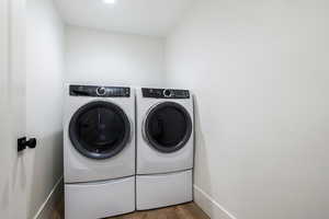 Laundry room featuring light wood finished floors and washer and dryer