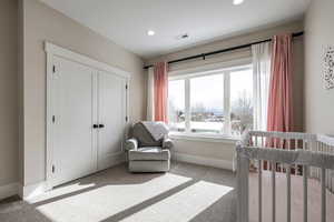 Bedroom with carpet floors, a closet, recessed lighting, and a nursery area
