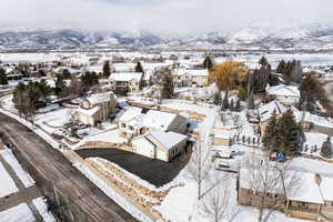 Snowy aerial view featuring a mountain view and a residential view