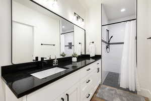 Full bath with double vanity, a stall shower, recessed lighting, and light wood-type flooring
