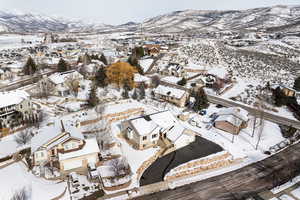 Snowy aerial view with a mountain view and a residential view