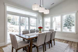 Dining space featuring lofted ceiling, light wood finished floors, and plenty of natural light