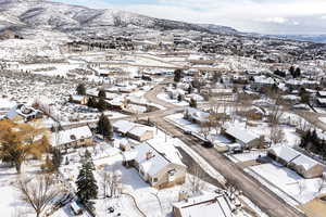 Snowy aerial view featuring a mountain view and a residential view