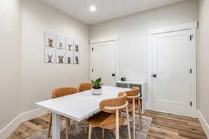 Dining room with light wood-style flooring and recessed lighting