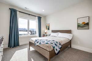 Bedroom with light carpet, recessed lighting, and a mountain view