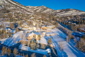 Snowy aerial view with a mountain view and a residential view
