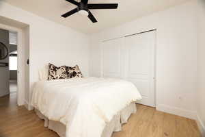 Bedroom featuring light wood-style flooring, a closet, and a ceiling fan