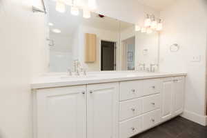 Full bathroom featuring double vanity and dark tile patterned flooring
