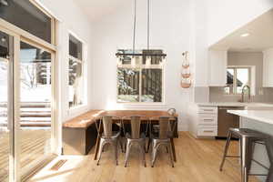Dining space featuring light wood-type flooring and lofted ceiling