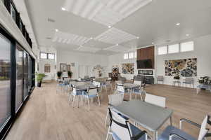 Dining room featuring light wood-style floors, a high ceiling, and recessed lighting