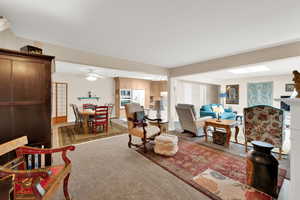 Living room with light colored carpet and a ceiling fan