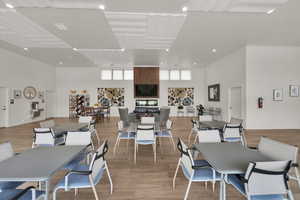 Dining room with light wood finished floors, a high ceiling, and recessed lighting