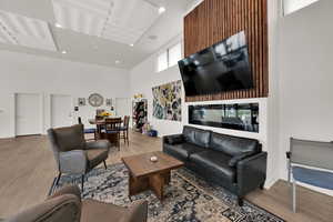 Living room featuring a high ceiling, wood finished floors, and recessed lighting