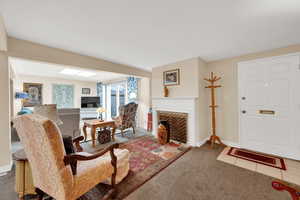 Living area with carpet flooring and a fireplace
