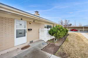 Doorway to property featuring brick siding and a chimney