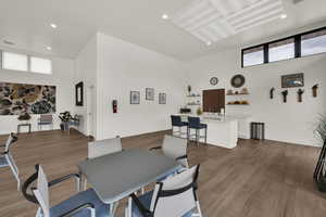 Dining space with a high ceiling, dark wood-type flooring, and recessed lighting