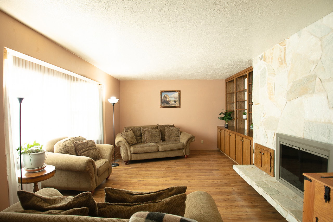 Living area with a fireplace, light wood-style floors, and a textured ceiling