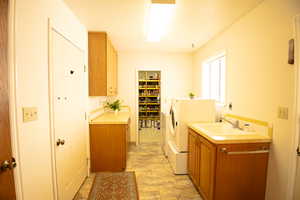 Laundry room on main level featuring cabinet space and washer and clothes dryer