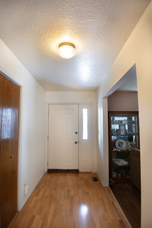 Entrance foyer with a textured ceiling and light wood finished floors