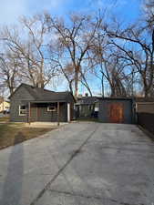 View of front of property with an outdoor structure and concrete driveway