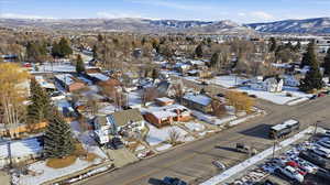 Snowy aerial view featuring a mountain view and a residential view