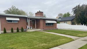 Red brick facade featuring a covered entry and a prominent brick chimney