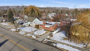 Snowy aerial view featuring a mountain view and a residential view