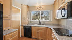 Kitchen featuring black appliances and light wood finish cabinets