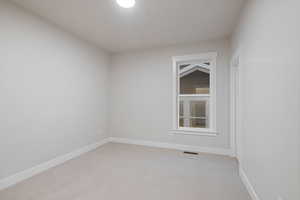 Unfurnished room featuring light colored carpet and baseboards