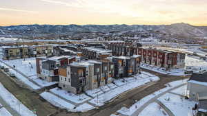 Snowy aerial view featuring a mountain view and a residential view