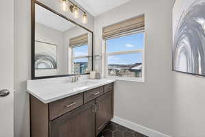 Bathroom with vanity and dark tile patterned flooring