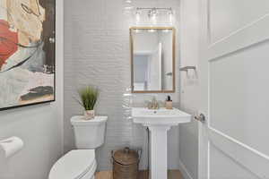 Bathroom with toilet and tile walls