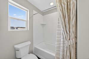 Full bath featuring shower / tub combo with curtain and recessed lighting