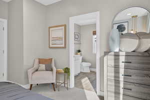 Bedroom with light wood-style flooring and ensuite bath