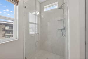 Full bathroom with a marble finish shower