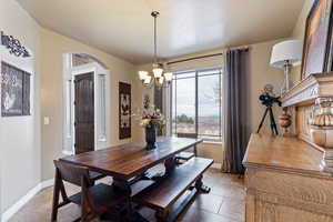 Dining area featuring baseboards and a chandelier