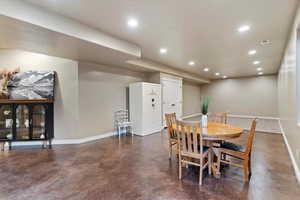 Dining room with finished concrete flooring and recessed lighting