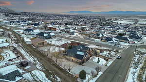 Snowy aerial view featuring a mountain view and a residential view