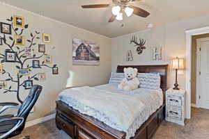 Carpeted bedroom featuring a ceiling fan and baseboards