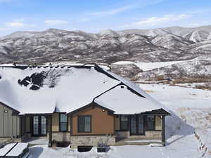 View of front facade featuring stone siding, french doors, and a mountain view