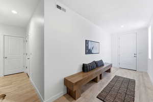 Foyer entrance with light wood-style floors and recessed lighting