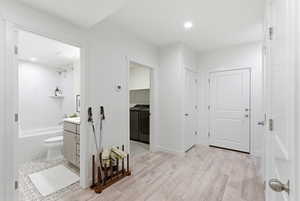 Full bath featuring vanity, washing machine and clothes dryer, shower / bath combination, light wood-style flooring, and recessed lighting