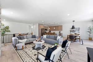 Living area with light wood-type flooring and recessed lighting
