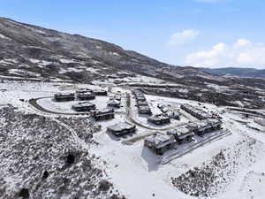 Snowy aerial view featuring a mountain view and a residential view