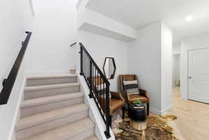Staircase with baseboards and wood finished floors